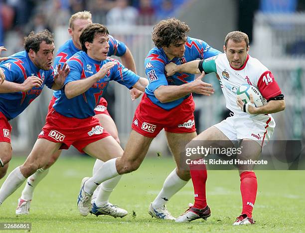 Philippe Bidabe of Biarritz avoids the tackle of Stade Francais' Olivier Sarramea during The Heineken Cup Semi Final match between Stade Francais and...