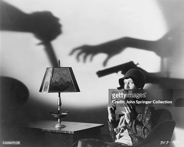 Scared actress Jean Arthur holds a book for a publicity still for the 1929 mystery film The Greene Murder Case in which she stars as character Ada...