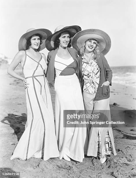 Portrait of actresses Frances Dee , Adreienne Ames , and Judith Wood arm in arm on the beach. All actresses had signed contracts with Paramount...