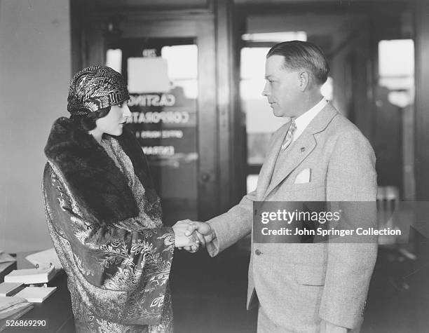 Wyman, general manager of the Central Casting Corporation which supplies talent to the principal studios, courteously meets screen actress Lolita Lee.