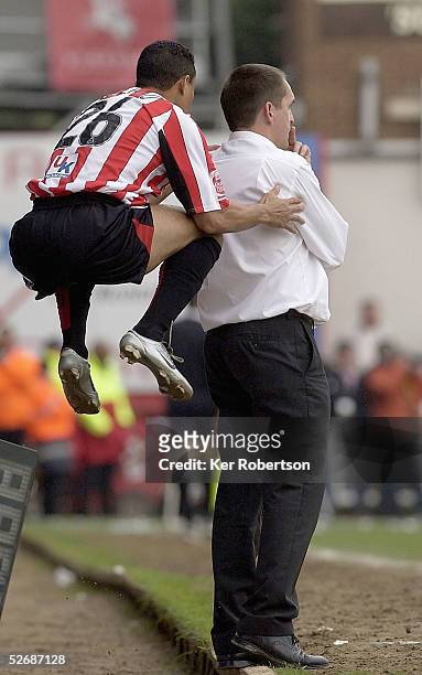 John Salako of Brentford jumps on the back of his manager Martin Allen whilst warming up to come on during the Coca-Cola League One match between...
