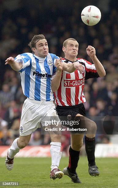 Chris Brandon of Huddersfield Town and Andy Frampton of Brentford challenge for the ball during the Coca-Cola League One match between Brentford and...