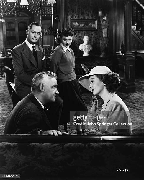 Scene from the 1948 film June Bride. Linda Gilman played by Bette Davis talks with a man, while Carey Jackson and Barbara Brinker look on.