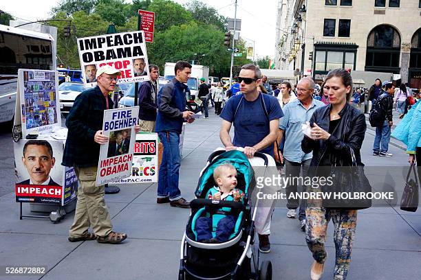Lyndon LaRouche supporters with signs calling for impeaching President Obama and firing Speaker of the House, John Boehner. Signs with Hitler...