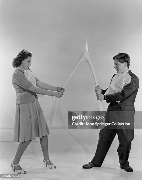 Judy Garland and Mickey Rooney break a large wish bone.