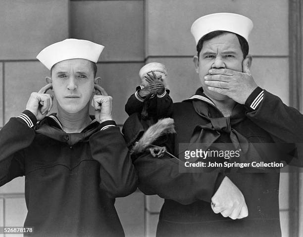 Stan Laurel and Oliver Hardy, together with their new leading lady, Mary the monkey, exemplify the motto, See no evil, hear no evil and speak no evil.