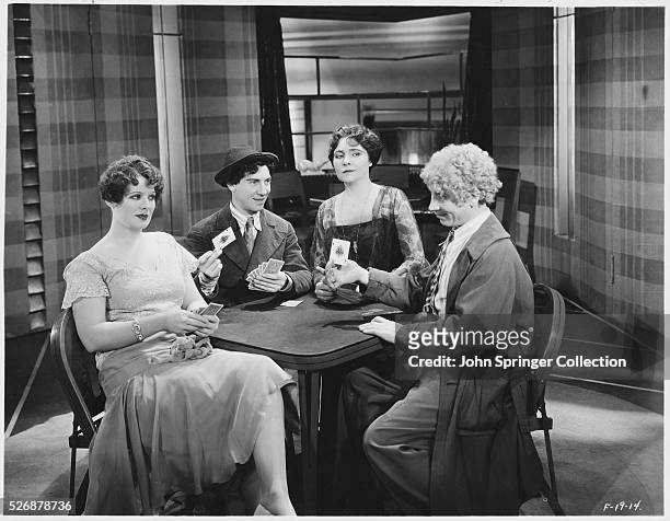 Margaret Irving, Chico Marx, Margaret Dumont, and Harpo Marx play a game of cards in the 1930 Marx Brothers comedy, Animal Crackers.