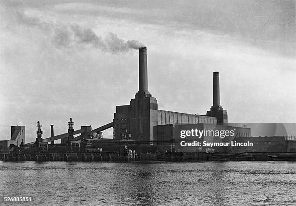 Battersea Power Station, a coal-fired power station on the south bank of the River Thames in London, circa 1935. It is pictured here between the...