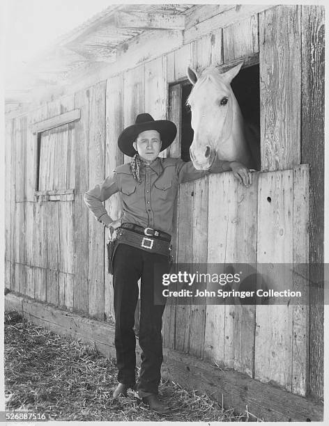 Western movie star Tex Ritter stands with his horse, White Flash.