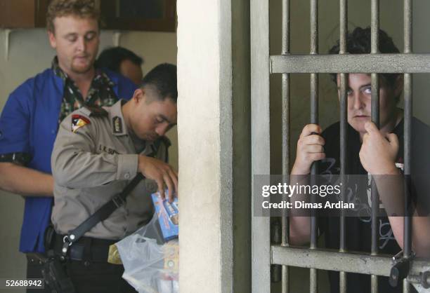 Year-old woman Renae Lawrence of Newcastle, Australia, is seen behind her cell bars, as an Indonesian police officer checks food supply given by...