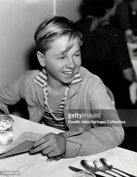 Mickey Rooney about to order lunch in a restaurant. The youthful Mero-Goldwyn-Mayer actor recently appeared in Hunt Stromberg's production of Ah,...