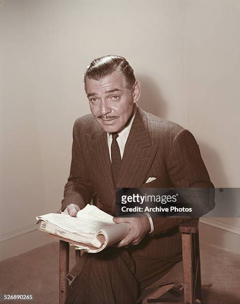 American actor Clark Gable reading a script, circa 1955.