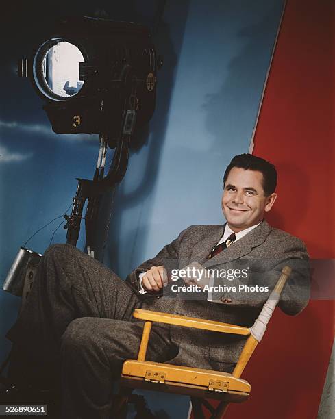 Canadian-born American actor Glenn Ford sitting in front of a Columbia Pictures Corporation studio light, circa 1957.