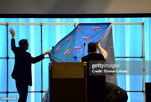 Members of the Alternative fuer Deutschland political party take away the transparent with the party logo after he party's federal congress on May...