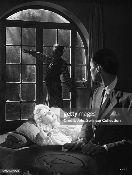 Rex Harrison as Charles Condomine, Kay Hammond as Elvira Condomine, and Margaret Rutherford as Madame Arcati in the 1945 film Blithe Spirit.