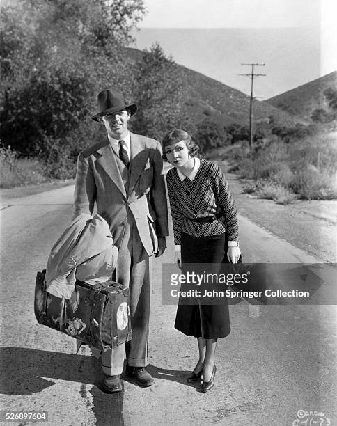Movie still from the 1934 film, "It Happened One Night." In this scene, Claude Colbert and Clark Gable are shown hitch-hiking.