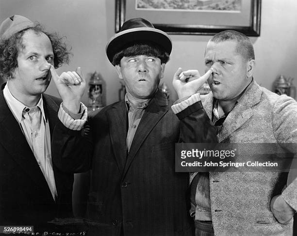 Moe takes control of the situation by placing his fingers in the nostrils of Larry and Curly.