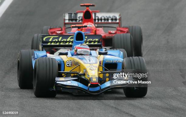 Fernando Alonso of Spain and Renault leads second placed Michael Schumacher of Germany and Ferrari during the San Marino F1 Grand Prix at the San...