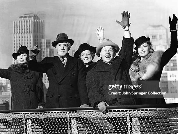 The cast of the 1940 musical Andy Hardy Meets Debutante waving from a studio recreation of New York. Left to right are Sara Haden as Aunt Milly,...