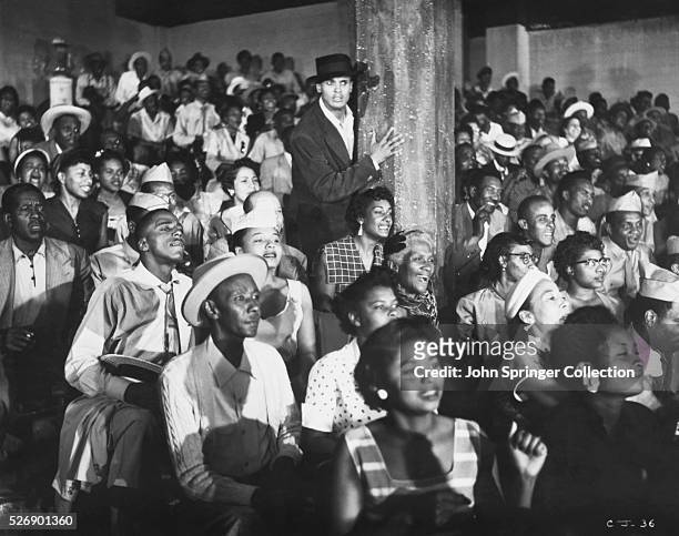 Joe stands in the middle of a crowd in the 1954 film Carmen Jones.