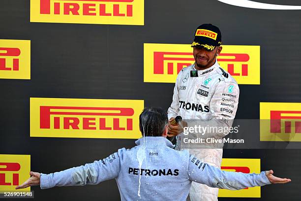 Lewis Hamilton of Great Britain and Mercedes GP sprays Kevin Taylor, Mercedes GP Head of Composites on the podium during the Formula One Grand Prix...