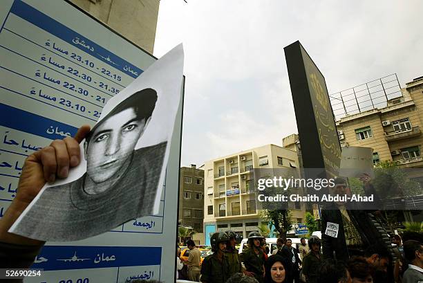 Syrian human rights activist holds a picture of Rshid Mahmood al-Sheik, demanding his release from jail, in front of the State Security Court In...