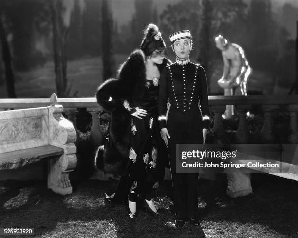 Jetta Goudal as Simone and Marion Davies as Sally disguised as a bellhop in the 1928 silent film The Cardboard Lover.