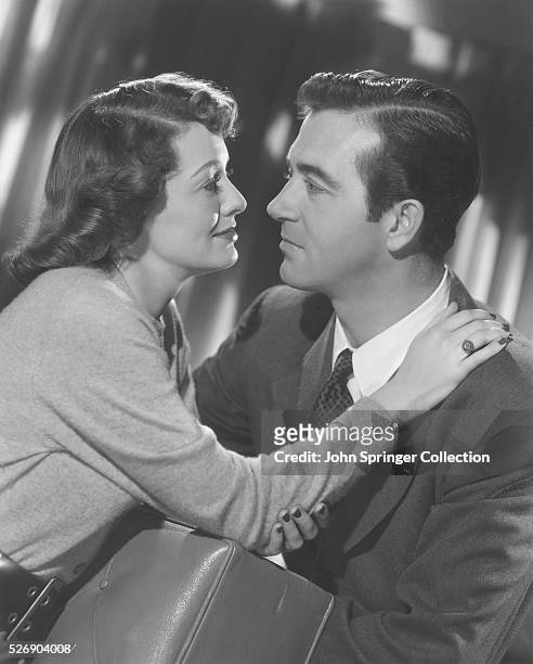 Eddie Rice and Nina hold each other and gaze into each other's eyes in a scene from the 1949 film The Crooked Way.