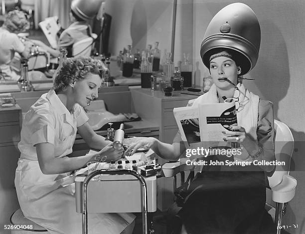Movie still from the film "The Women", showing Rosalind Russell, as Sylvia Fowler, and Dennie Moore as Olga, a manicurist. Photo shows Rosalind...
