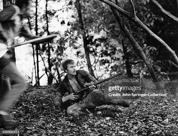 Actor Jon Voight as Ed Gentry and Burt Reynolds as Lewis Medlock take to a battle with rifles during an action shot in the 1972 film Deliverance.