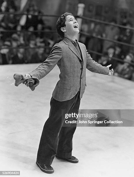 Gene Reynolds as the young Tommy McCoy singing in a boxing ring in the 1938 film The Crowd Roars.