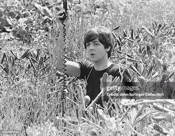 Paul McCartney holds up a phone in the 1965 film Help!. In the film, he tries to stop a cult from using Ringo as a human sacrifice.