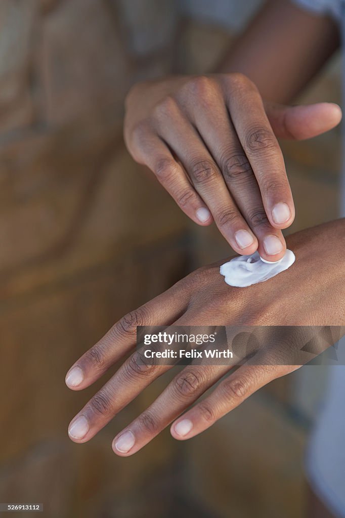 Woman applying lotion to her hand