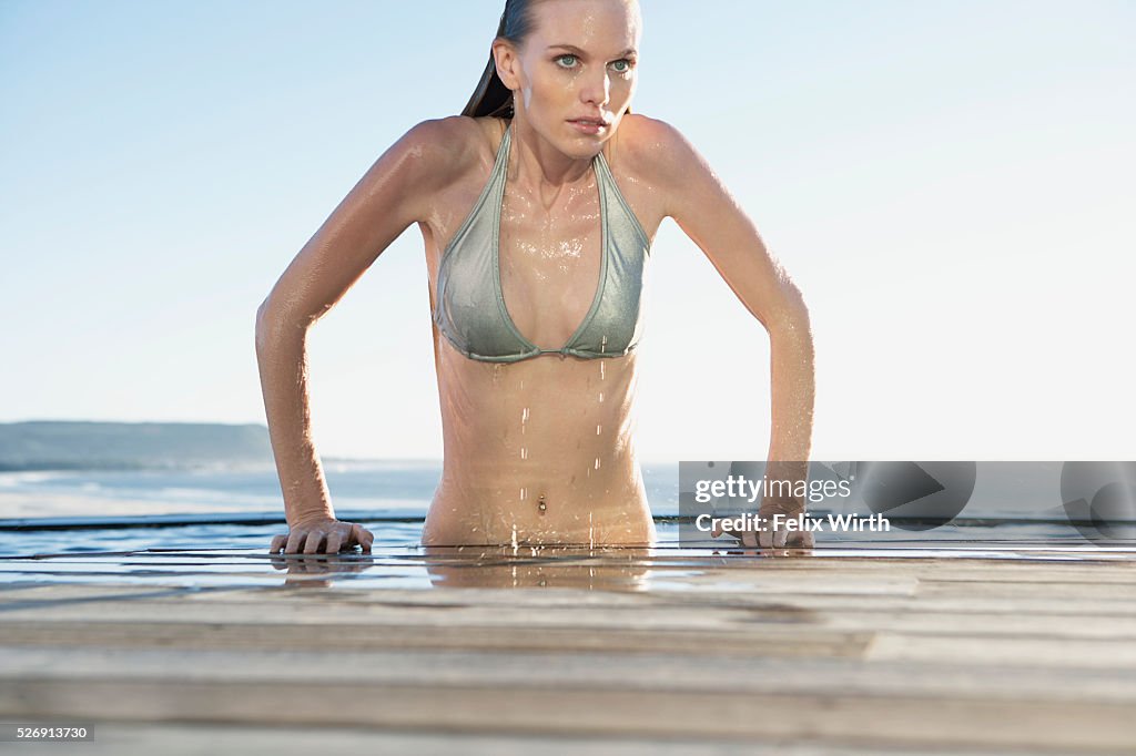 Woman emerging from swimming pool