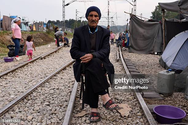An elder Kurd refugee from Aleppo, Syria sits on a cahir on the rails in the old Idomeni train station on May 1'st, 2016 in Idomein refugee camp....