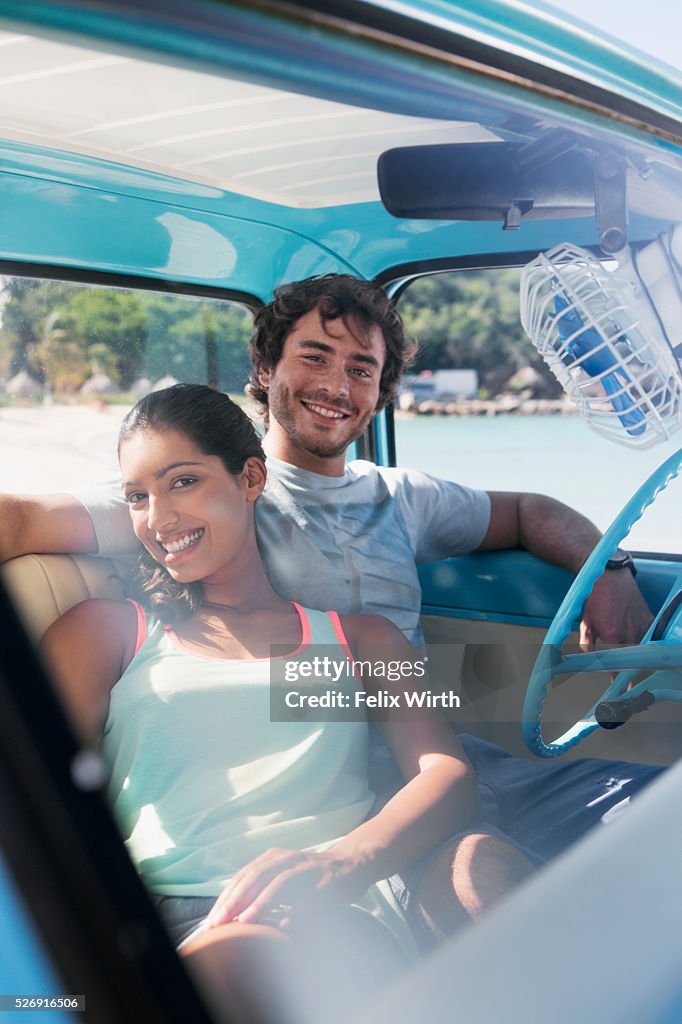 Couple sitting in car on beach