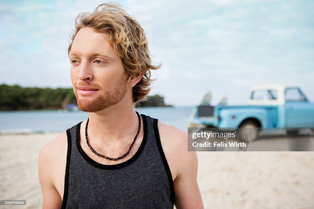 Portrait of man at beach, with pickup truck in background