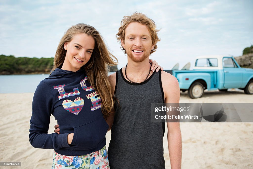 Portrait of couple at beach, with pickup truck in background