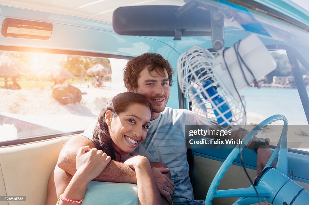 Couple sitting in car on beach