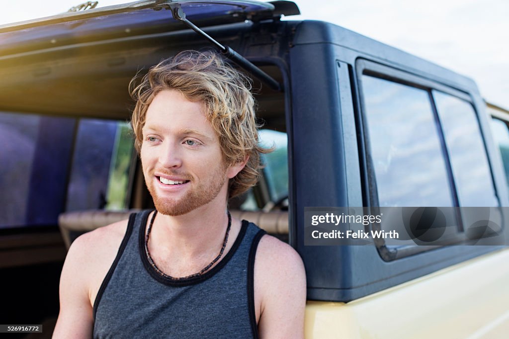 Portrait of man sitting at back of truck