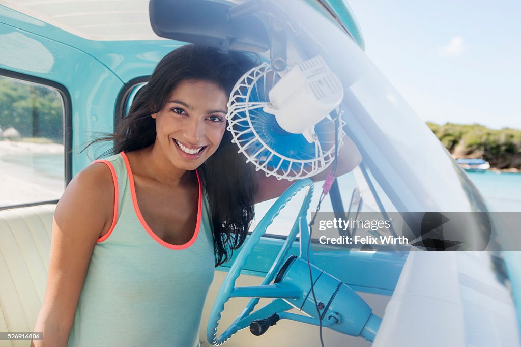 Woman sitting in car on beach