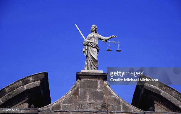 Robed figure, armed with sword and scales, the symbols of justice, stands above a gateway at Dublin Castle, in the old part of Dublin, Republic of...
