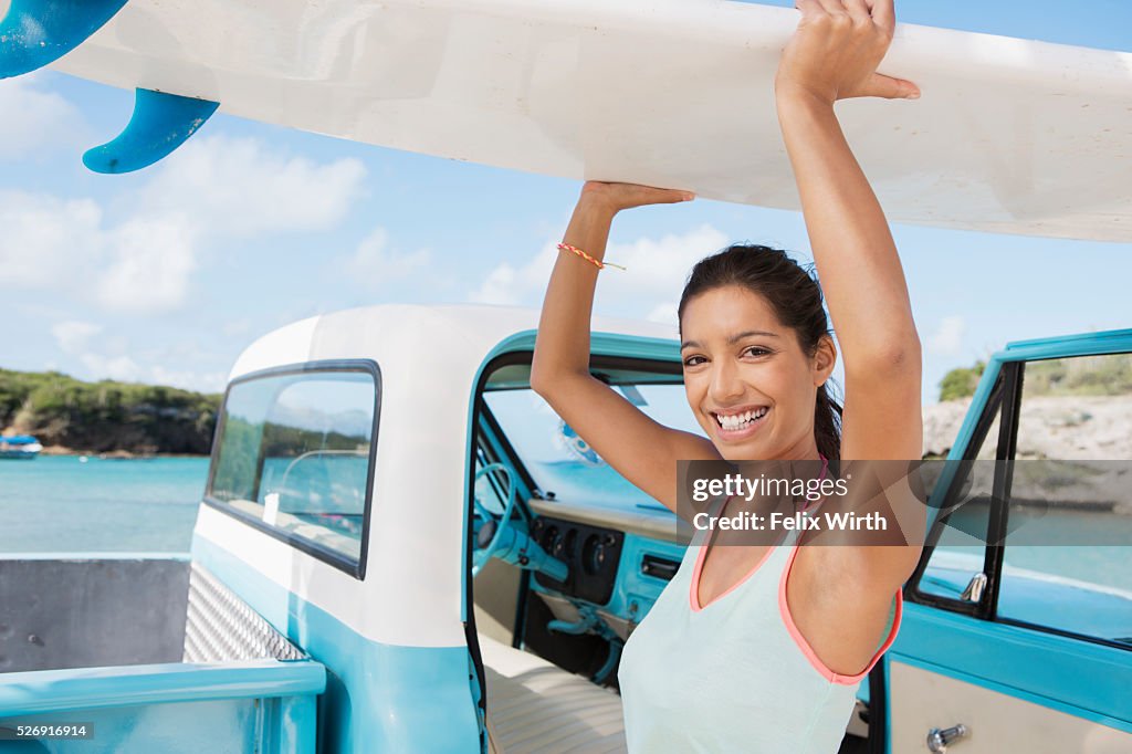 Woman carrying surfboard