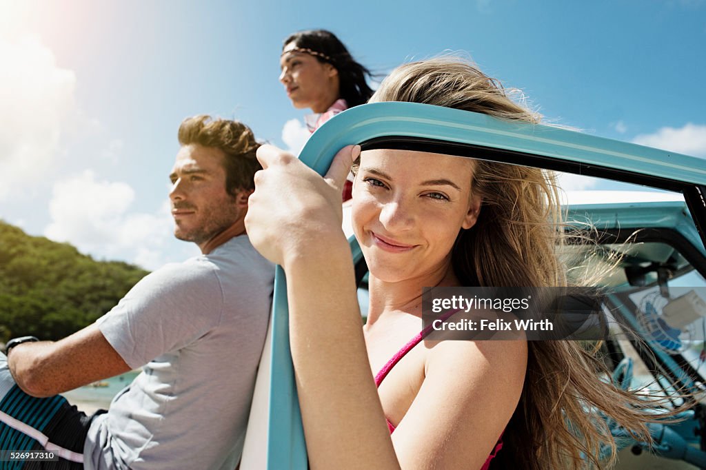 Group of friends with car on beach