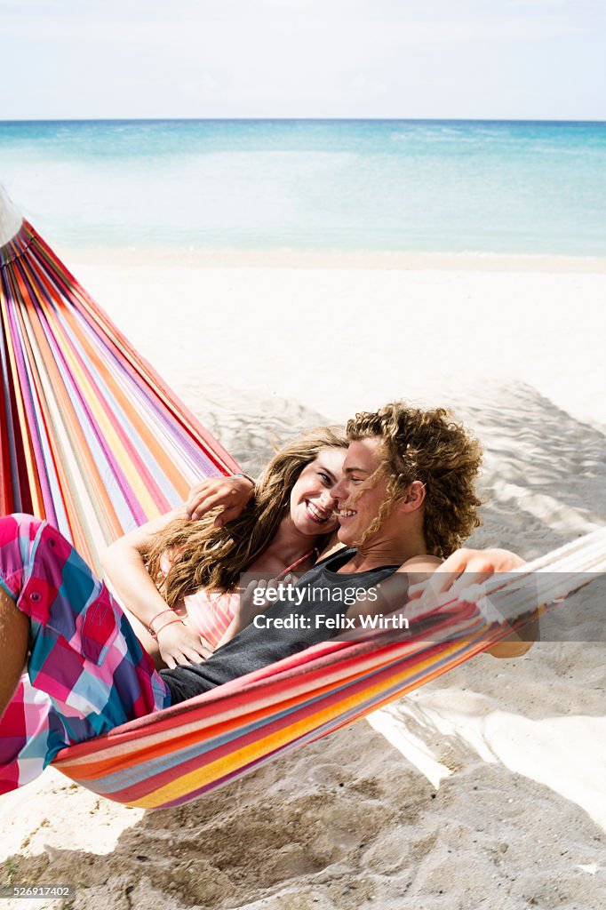 Young couple relaxing in hammock on beach