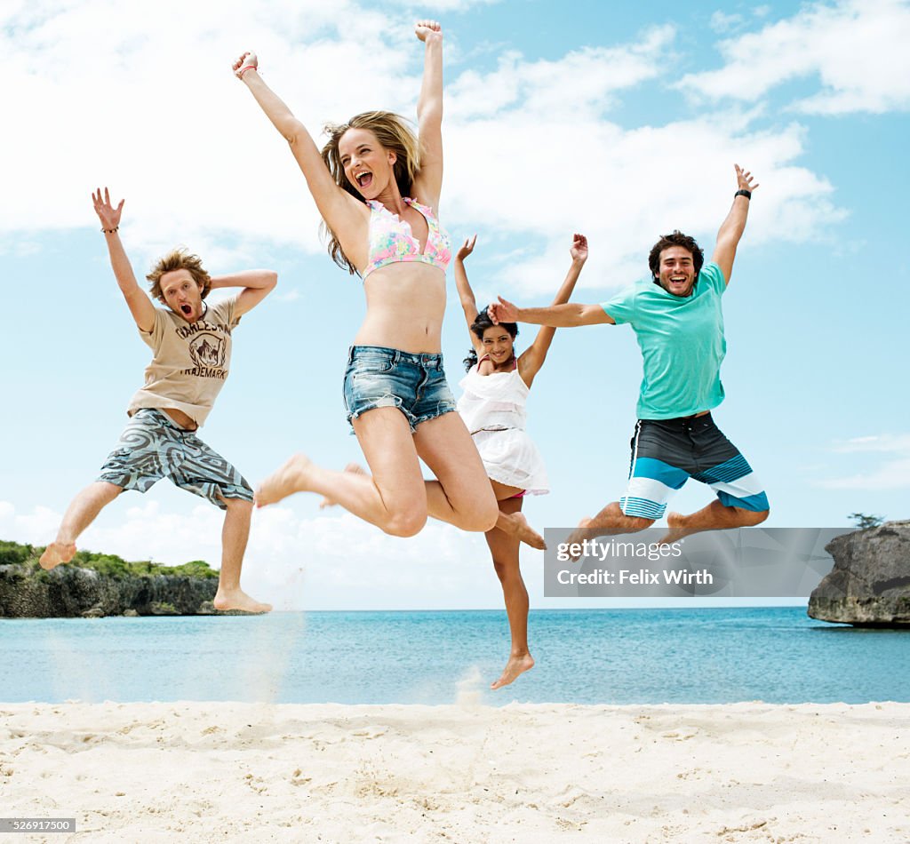 Young friends jumping on beach