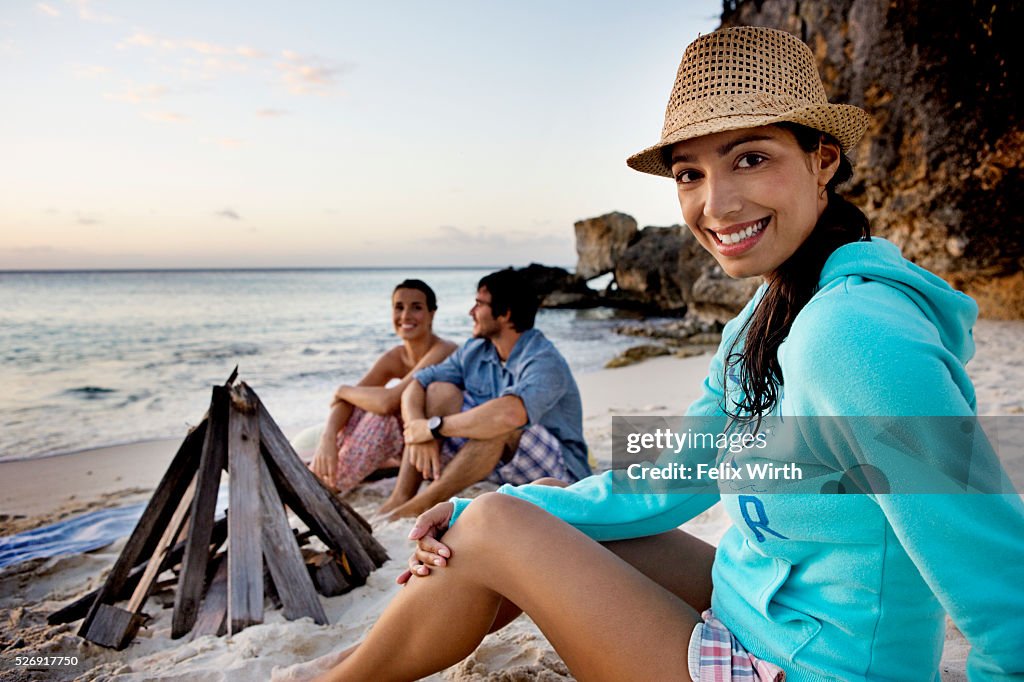 Friends sitting on beach at dusk