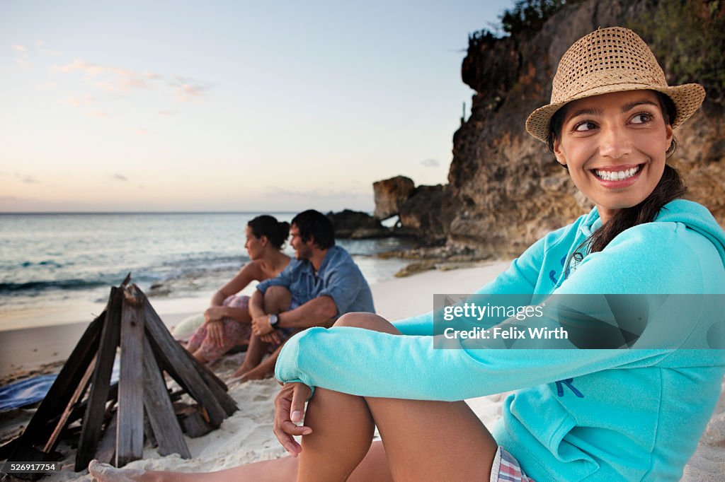 Friends sitting on beach at dusk