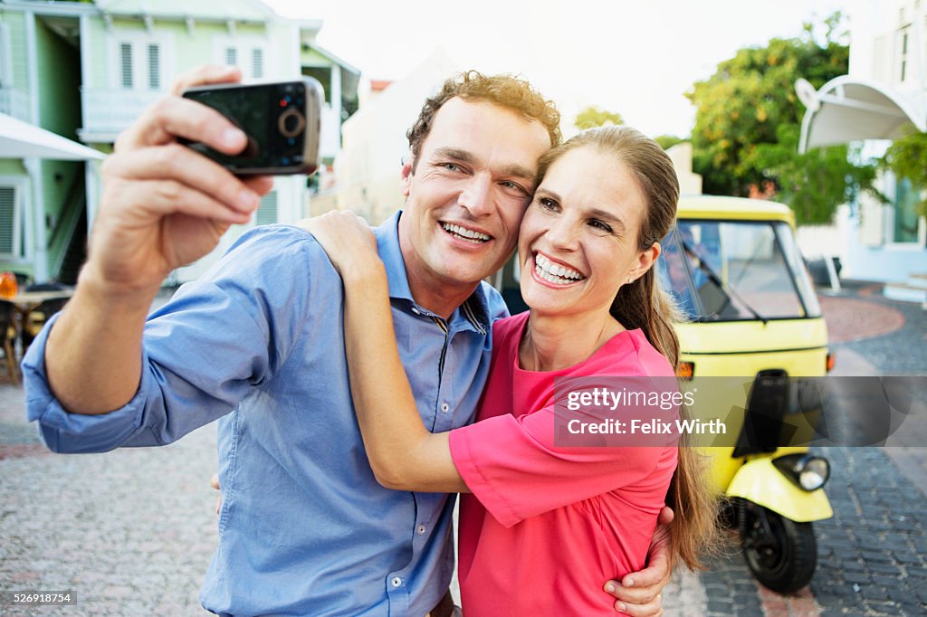 Couple taking picture in front of tuk tuk