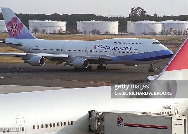 This photo taken 17 April 2005 shows a China Airlines jumbo passenger jet passing a Northwest Airlines jet parked on the tarmac at Narita...